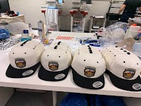 Custom embroidered polos and caps on display in our shop